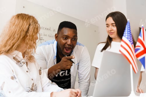 Preview: Attractive friendly-looking colleagues are working together in an office, discussing something.
