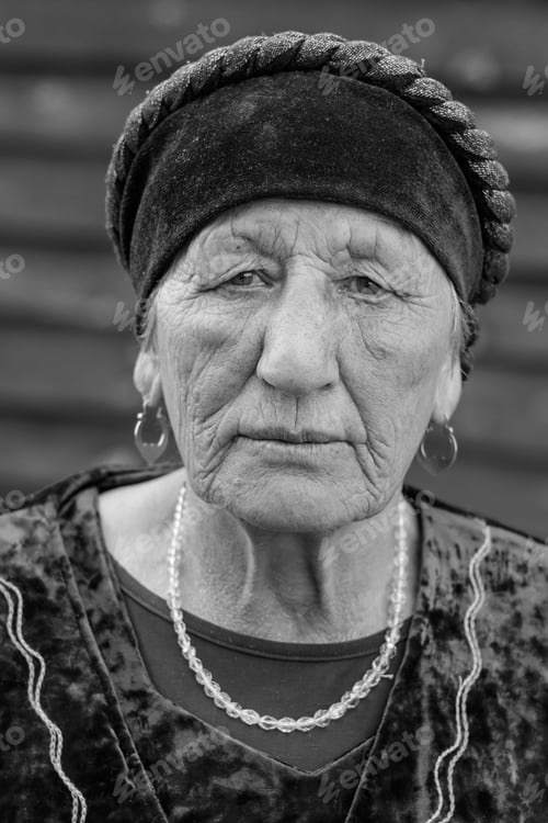 Preview: Close-up black-white portrait of a village elderly woman in a national costume