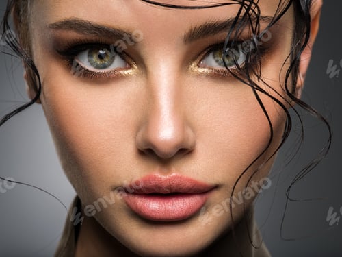 Vista previa: Closeup portrait of a beautiful young woman with brown gkamour makeup. Model looking at camera.