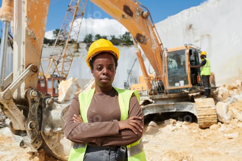 Preview: Young confident black woman in workwear and protective helmet