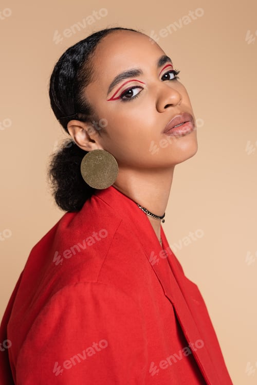 Preview: portrait of pretty african american model in bright red blazer posing isolated on beige