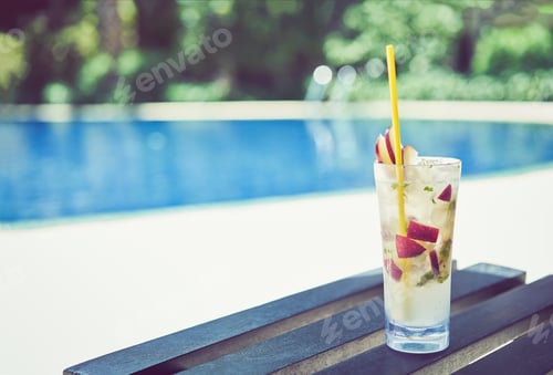 Preview: A glass of water juice on swimming pool in vacation and summer time.