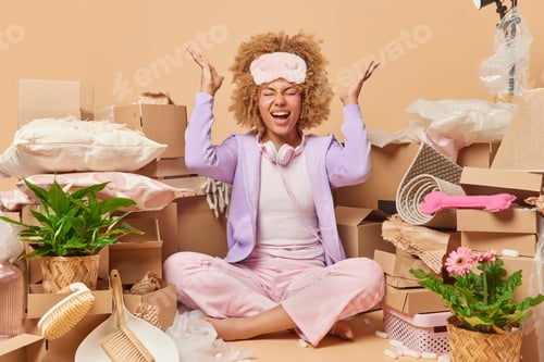 Preview: Emotional curly haired woman exlaims loudly keeps palms raised sits crossed legs on floor around car