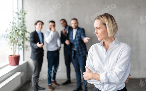 Preview: Male Coworkers Whispering Behind Unhappy Victimized Business Lady In Office