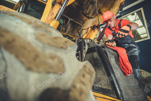 Preview: Man Repairing Heavy Construction Vehicle Engine Indoors