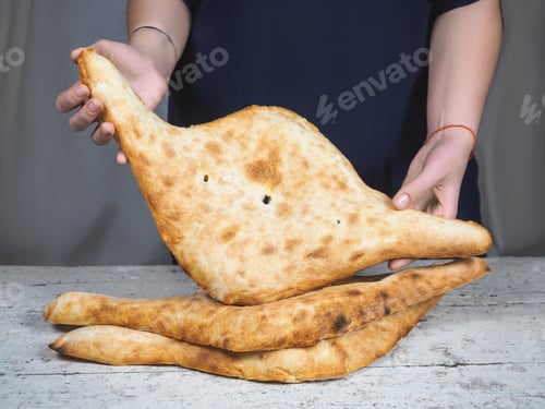 Preview: close-up partial view of person holding delicious traditional georgian lavash