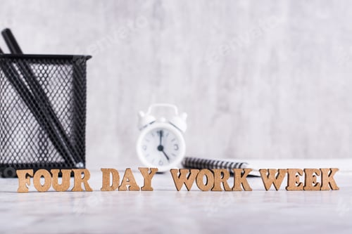 Preview: Four day work week word from wooden letters on desktop
