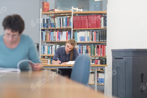 Preview: Female students reading textbooks at library desks