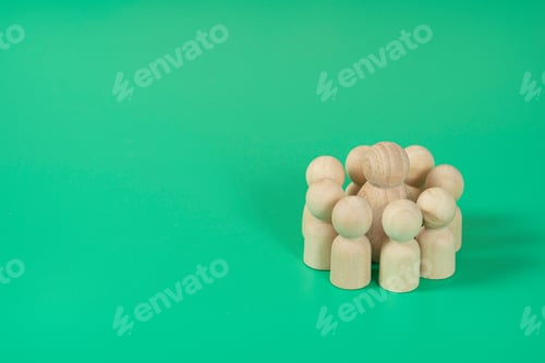 Preview: Small wood model circling a single bigger wood model symbolizing team hierarchy on green background