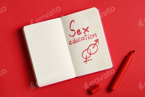 Preview: Notebook with phrase "SEX EDUCATION" on red background, flat lay. Space for text