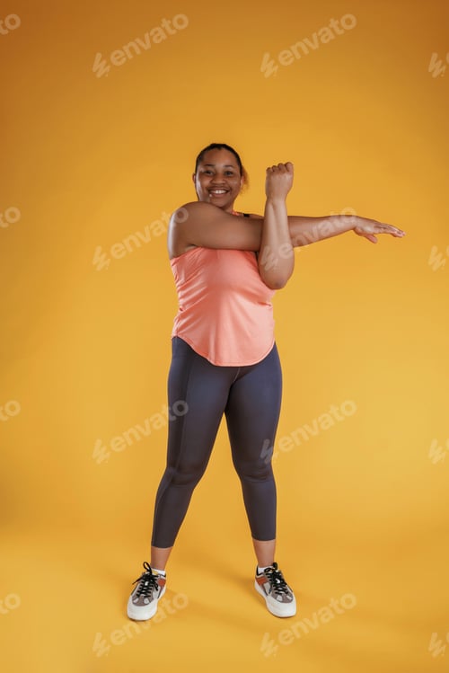 Preview: Warm up exercises for hands. African American woman is in the studio against yellow background
