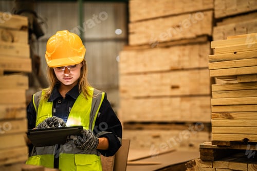 Preview: woman worker carpenter checking the quality of wooden products a