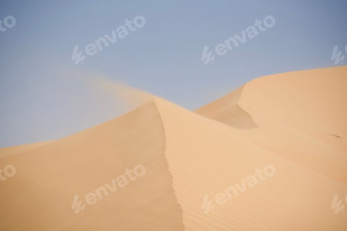 Preview: Desert wilderness wind blows sand at the top of a red sand dune