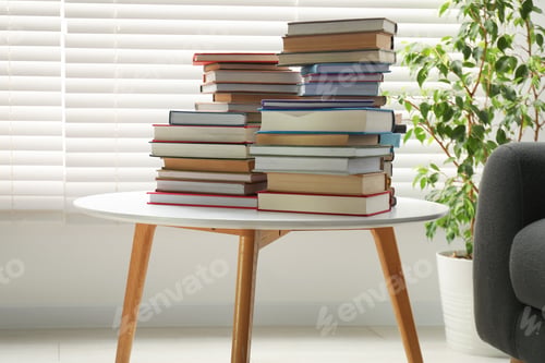 Preview: Many stacked books on white table indoors