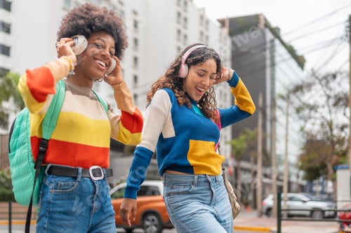 Preview: Young women happily listening to music and dancing in the street