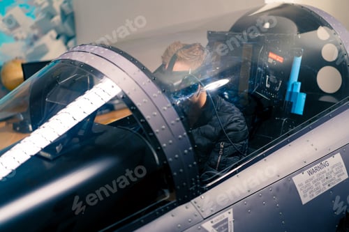 Preview: boy sitting in flight simulator military plane wearing virtual reality glasses flight entertainment