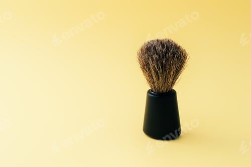 Preview: Closeup shot of a shaving brush isolated on a yellow surface