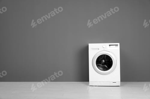 Preview: Empty washing machine near color wall, space for text. Laundry day
