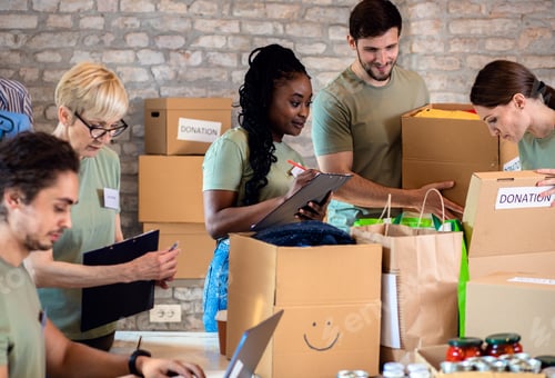 Preview: Group of volunteers with working in community charity donation center.