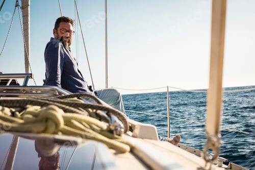 Preview: Adult man sit down on the sail boat deck enjoying the trip - travel lifestyle people on yacht