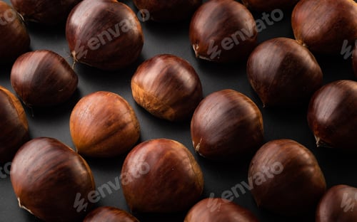 Preview: Rows of chestnuts isolated on black background