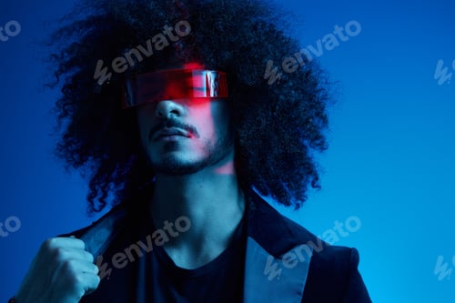Preview: Fashion portrait of a man with curly hair on a blue background wearing red sunglasses, multinational