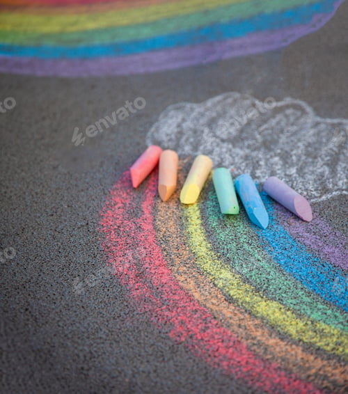 Preview: Sidewalk chalk drawing. A rainbow painted on the asphalt. Kids activities