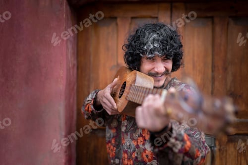 Preview: Portrait of a young Mexican musician posing with his jarana guitar as if it was a weapon