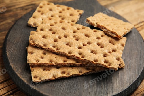 Preview: Board with fresh rye crispbreads on wooden table, closeup