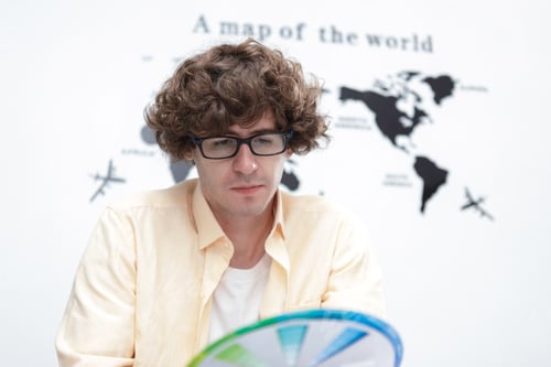 Preview: young caucasian man creative graphic designer selecting color swatch samples idea at modern office.