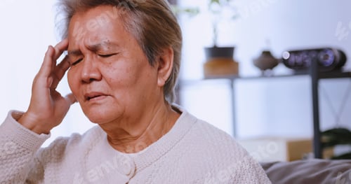Preview: Asian old woman with migraine headache. Elderly woman suffering from a headache.