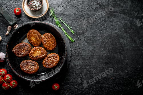 Preview: Cutlets in pan with rosemary, garlic and tomatoes.