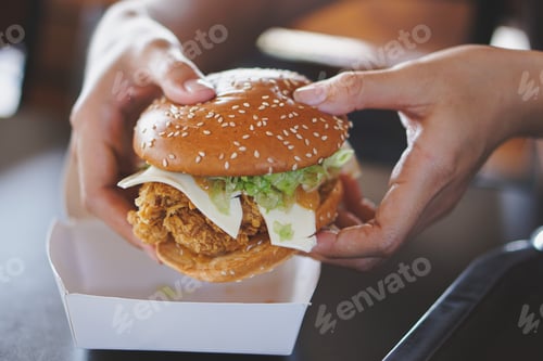Preview: tasty burger. stylish hipster woman holding juicy hamburger in hands close up.