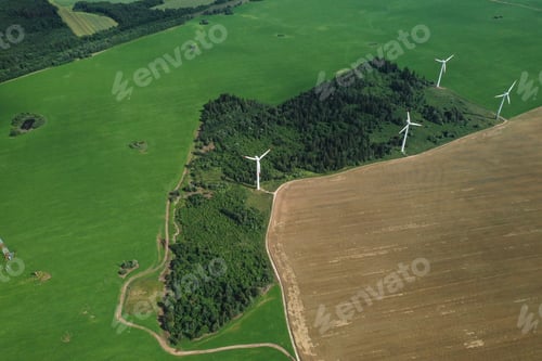 Preview: Windmills in summer in a green field.large windmills standing in a field near the forest.Europe