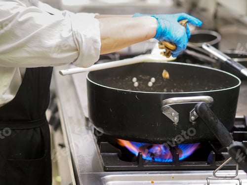 Preview: chelf cooking at restaurant kitchen firing gas stoves and black pro pots