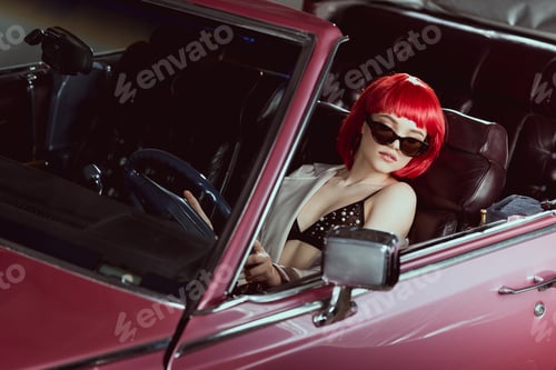 Preview: high angle view of beautiful girl in bra and sunglasses driving vintage car
