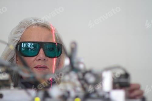Preview: Female scientist monitoring experiment in laser laboratory