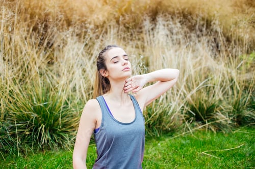 Preview: Young woman doing yoga exercise in green park