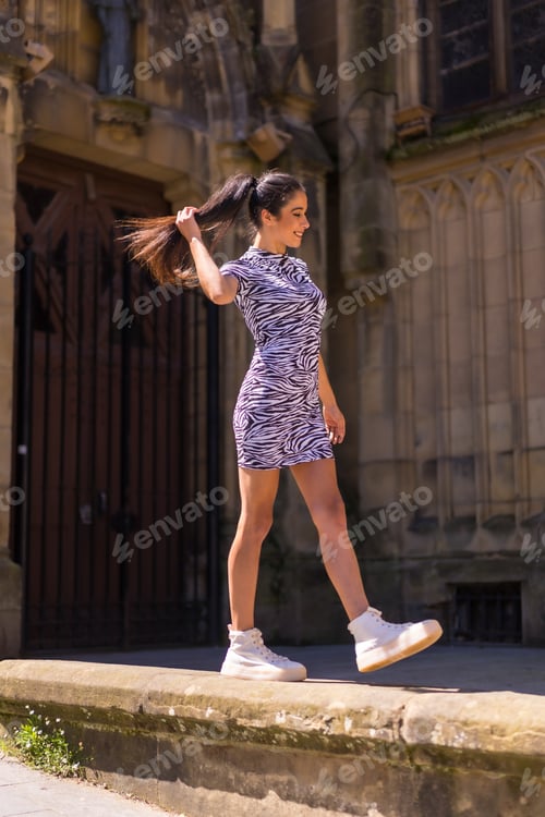 Preview: Young brunette posing in a church doorway in summer wearing a zebra print jumpsuit
