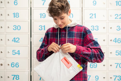 Preview: close up young person quickly unpackage the recieved delivery in post office,