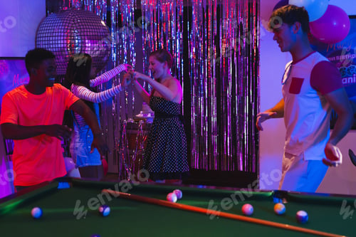 Preview: Teenagers dancing joyfully at party with pool table and disco ball