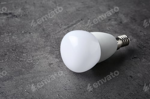 Preview: New modern lamp bulb on grey stone surface