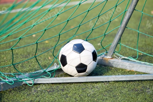 Preview: soccer ball at goal net on football field