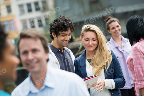 Preview: People outdoors in New York City. A group of men and women, a couple looking at a cell phone.
