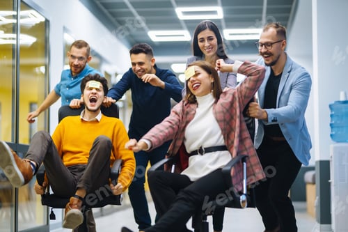 Preview: Young cheerful business people racing on office chairs and laughing. Funny activity
