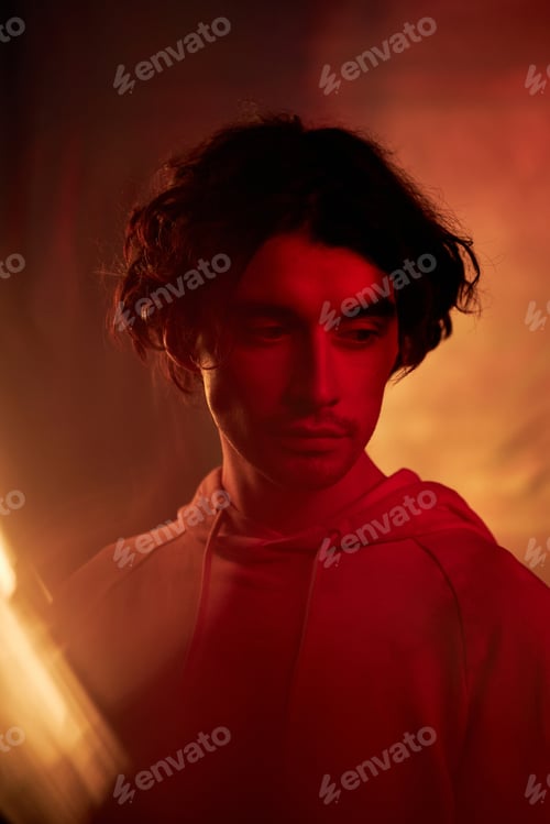Preview: Handsome Young Man with Wavy Hair in Red and Orange Light
