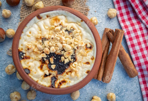 Preview: Baked rice pudding turkish milky dessert sutlac in earthenware casserole with hazelnuts