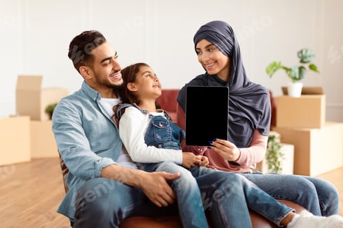 Preview: Happy muslim family doing repair woman showing tablet