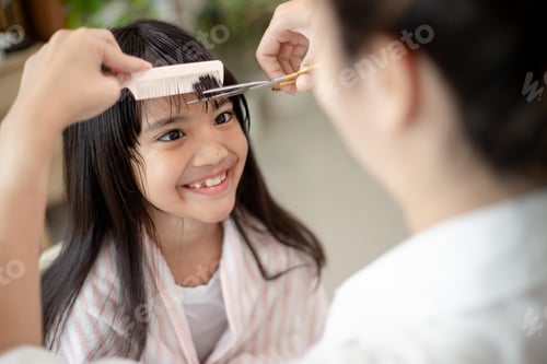 Preview: Smiling Girl Getting a Haircut at Home