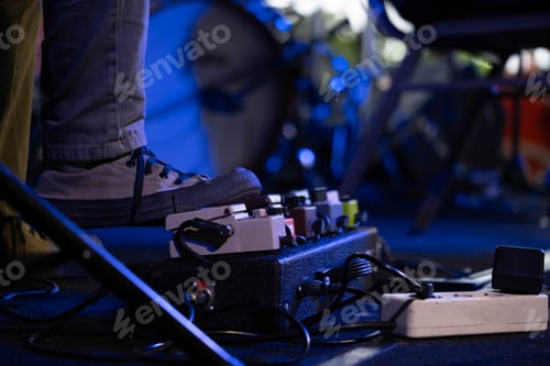 Preview: Musician using guitar effects pedal during live performance